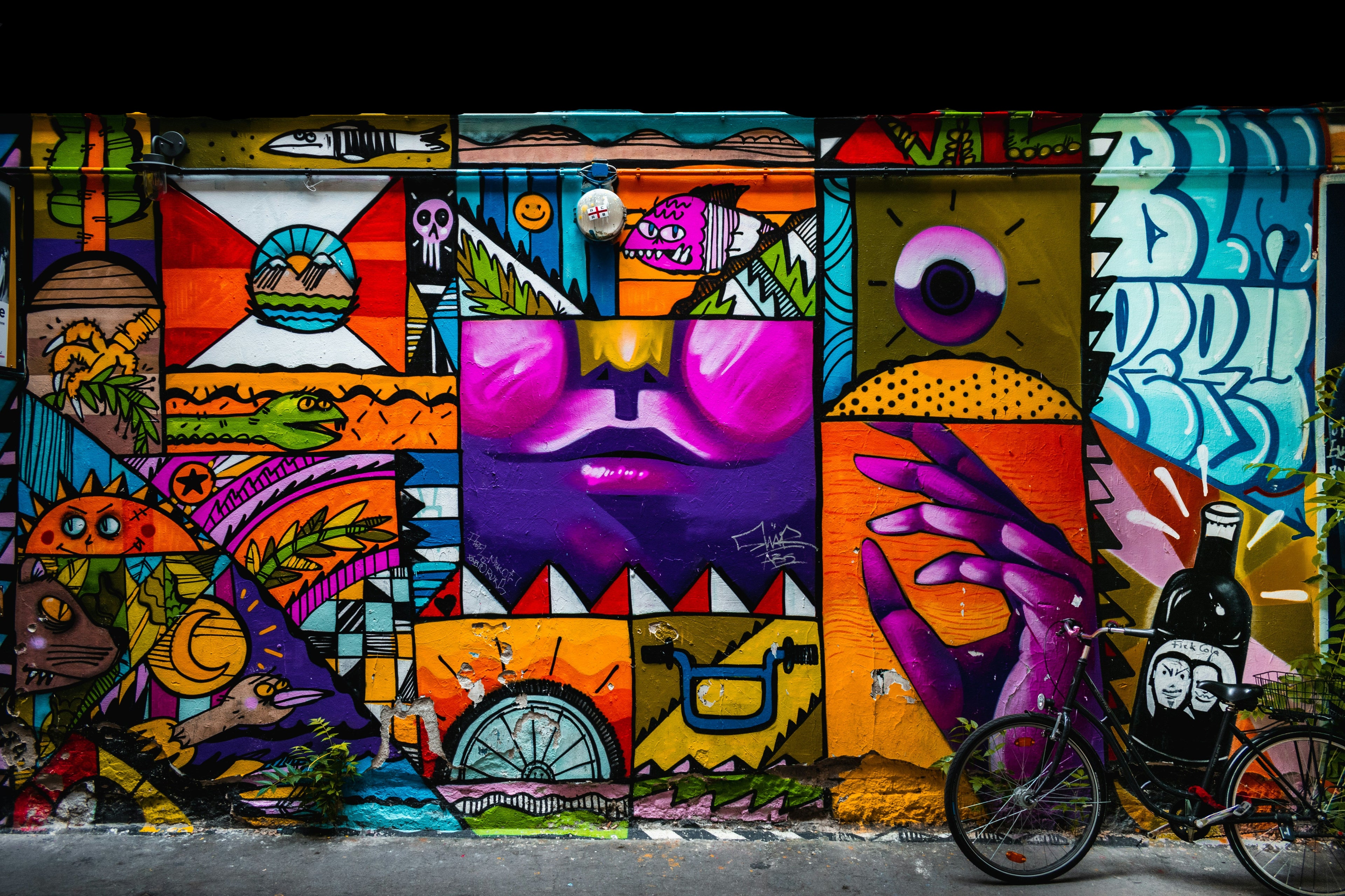 Colorful graffiti mural on a wall with a bicycle in the foreground.